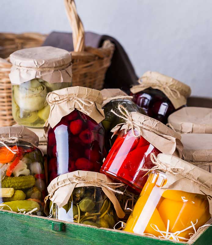 Verduras encurtidas dispuestas en una caja de madera, mostrando una variedad de colores.